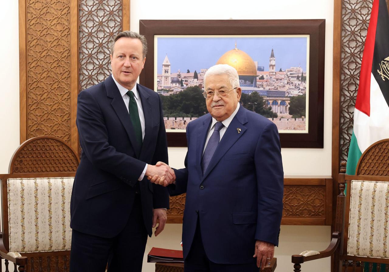 David Cameron (links) und Mahmud Abbas schütteln sich die Hände. Im Hintergrund ein Bild von Jerusalem und die palästinensische Flagge.