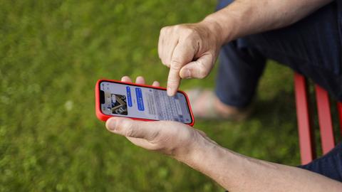 Ein Mann verschickt auf einem Smartphone eine Chatnachricht