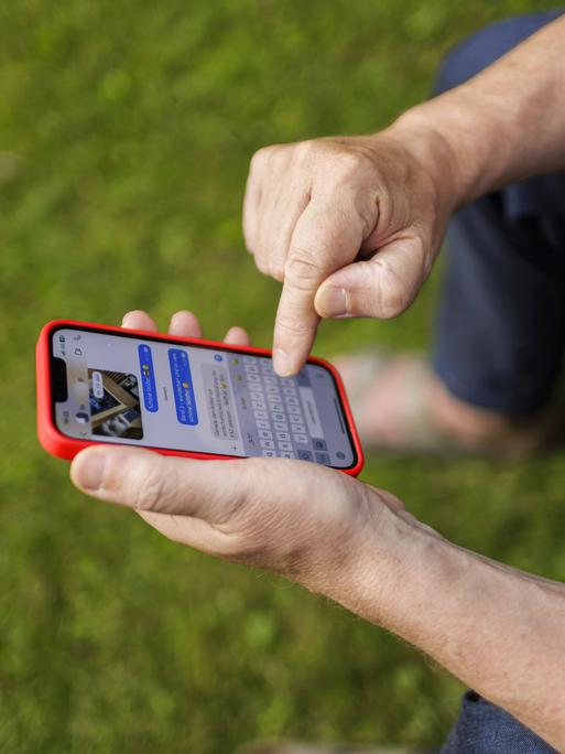 Ein Mann verschickt auf einem Smartphone eine Chatnachricht
