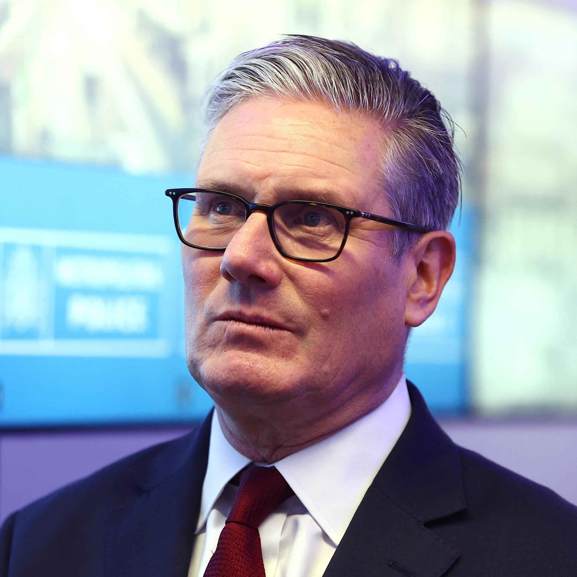 Keir Starmer blickt ernst in die Höhe.