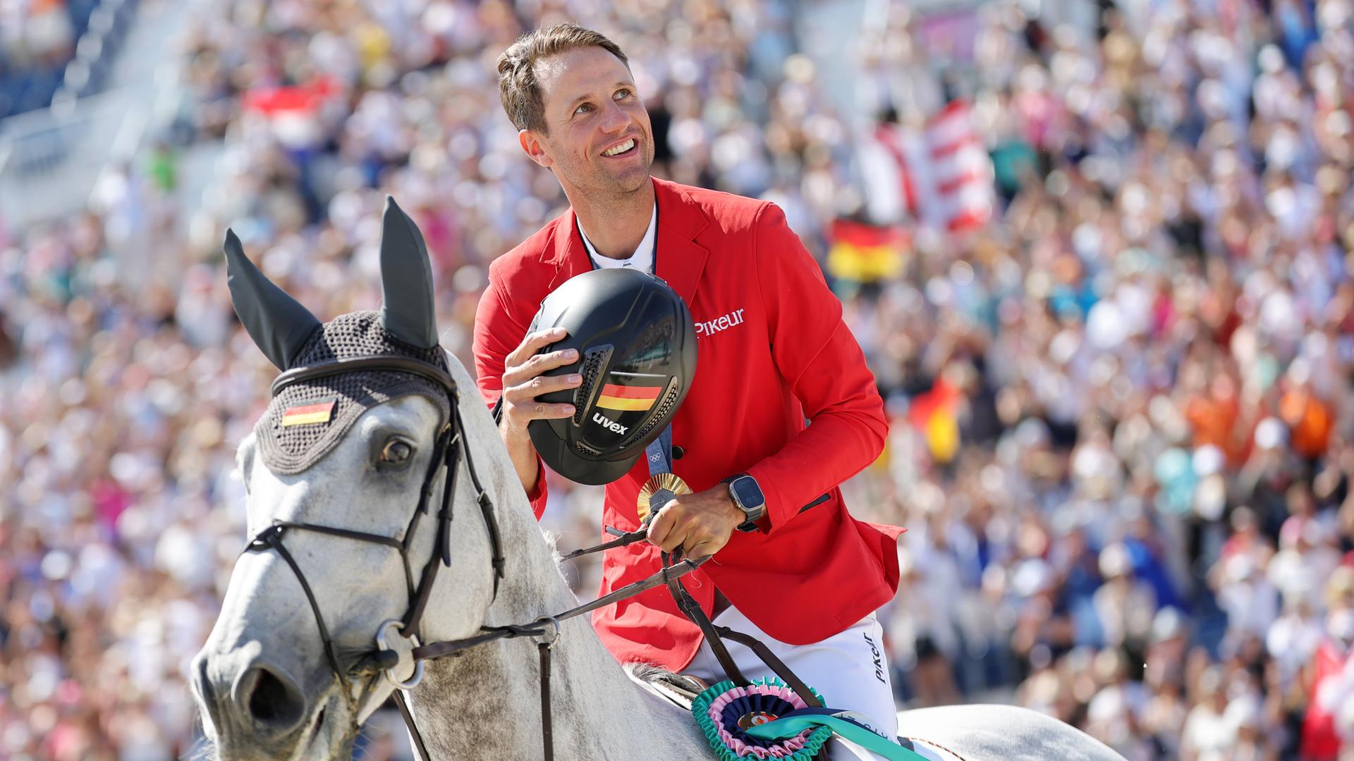 Deutschlands Springreiter Christian Kukuk jubelt nach der Siegerehrung auf seinem Pferd Checker.