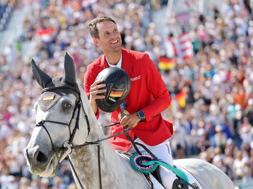 Deutschlands Springreiter Christian Kukuk jubelt nach der Siegerehrung auf seinem Pferd Checker.