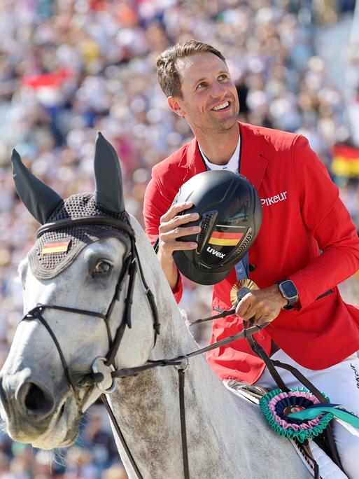 Deutschlands Springreiter Christian Kukuk jubelt nach der Siegerehrung auf seinem Pferd Checker.