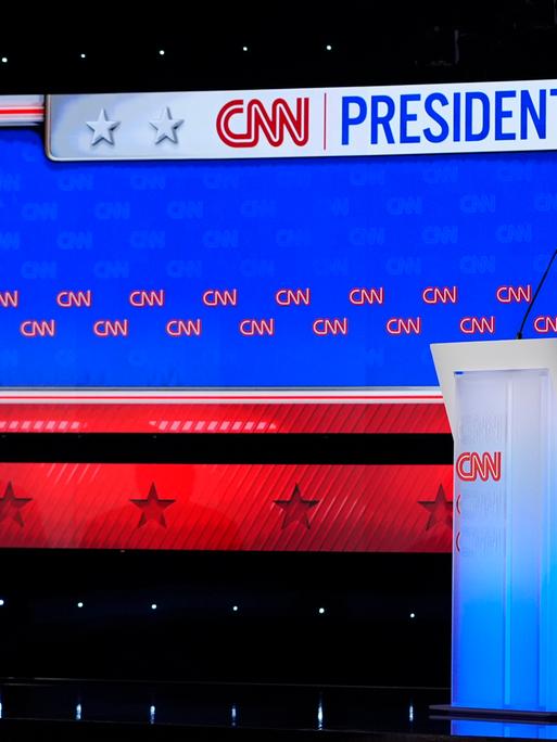 Donald Trump und Joe Biden in einem Fernseh-Studio. Beide stehen an einem Redner-Pult. Joe Biden dreht sich weg.