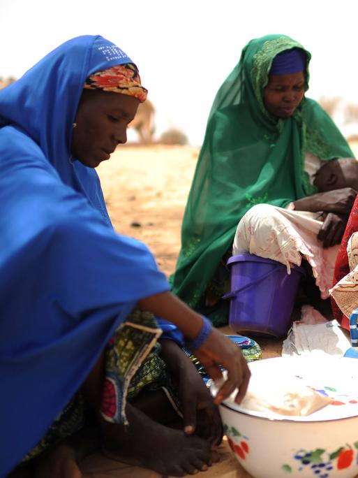 Frauen sitzen zusammen in der von Hunger bedrohten Sahelzone. 