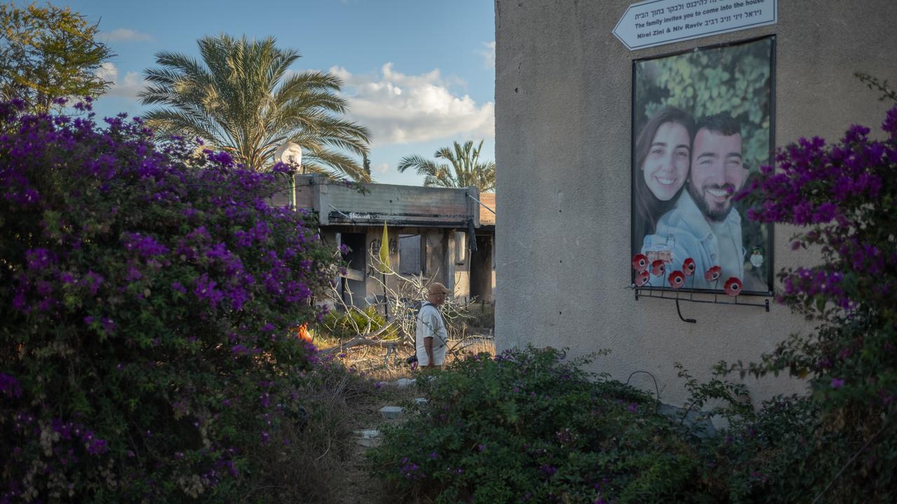 Ein Mann geht während einer Zeremonie zum zweiten Jahrestag des von der Hamas angeführten Angriffs vom 7. Oktober an einem Foto eines Paares in Kfar Aza vorbei. Ein Mann geht während einer Zeremonie zum zweiten Jahrestag des von der Hamas angeführten Angriffs vom 7. Oktober an einem Foto eines Paares in Kfar Aza vorbei.