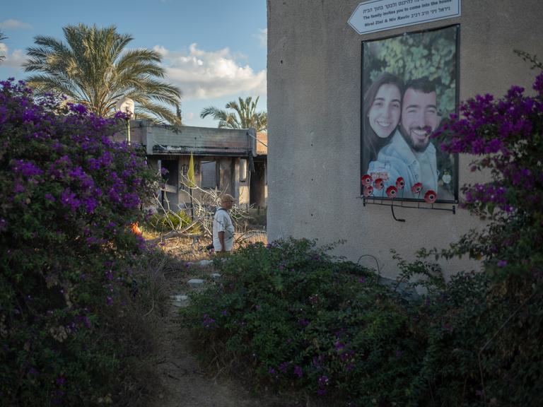 Ein Mann geht während einer Zeremonie zum zweiten Jahrestag des von der Hamas angeführten Angriffs vom 7. Oktober an einem Foto eines Paares in Kfar Aza vorbei.