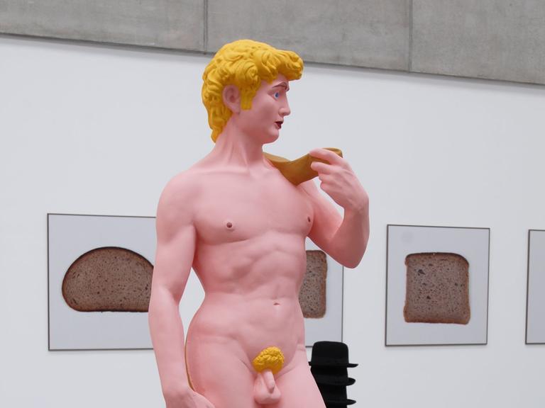 Die Skulptur eines nackten Mannes erinnert an den David von Michelangelo. Der Körper ist rosafarben, die Haare gelb. (Quelle: picture alliance)