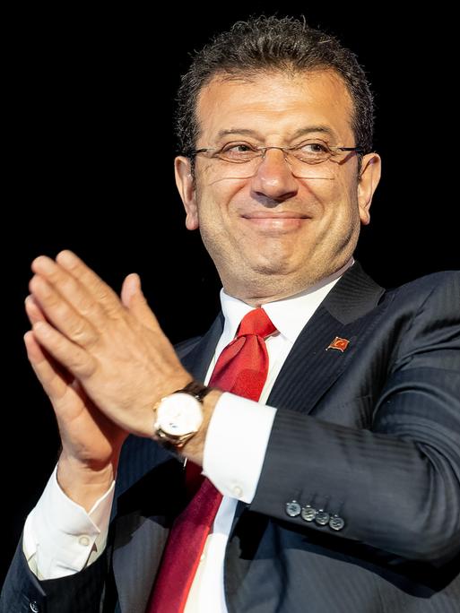 Der türkische Politiker Ekrem Imamoglu von der CHP lächelt von einer Tribüne herab