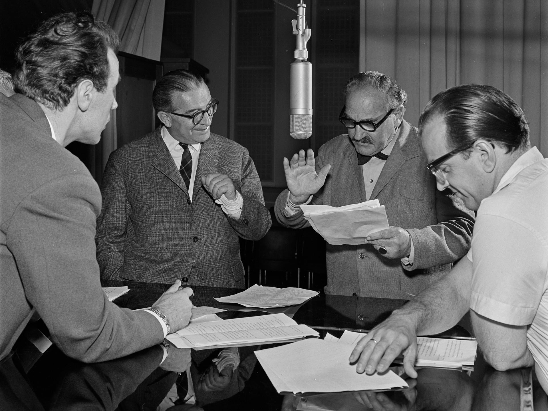 Die Science Fiction Hörspiel-Serie "Unternehmen Luna" wird im RIAS Radio im Jahr 1960 aufgenommen. Vier Schauspieler stehen um ein Mikrofon mit Textzetteln in der Hand.