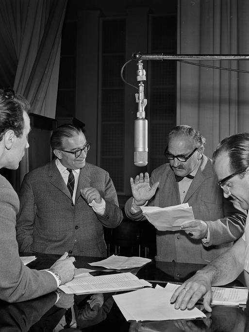 Die Science Fiction Hörspiel-Serie "Unternehmen Luna" wird im RIAS Radio im Jahr 1960 aufgenommen. Vier Schauspieler stehen um ein Mikrofon mit Textzetteln in der Hand. Die Science Fiction Hörspiel-Serie "Unternehmen Luna" wird im RIAS Radio im Jahr 1960 aufgenommen. Vier Schauspieler stehen um ein Mikrofon mit Textzetteln in der Hand.