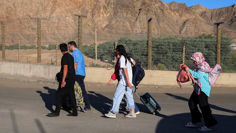 Menschen, überwiegend Iranerinnen und Iraner, die ihr Land aufgrund israelischer Angriffe verlassen haben, gehen über den Grenzübergang in der Nähe des Dorfes Agarak im Süden Armeniens. 