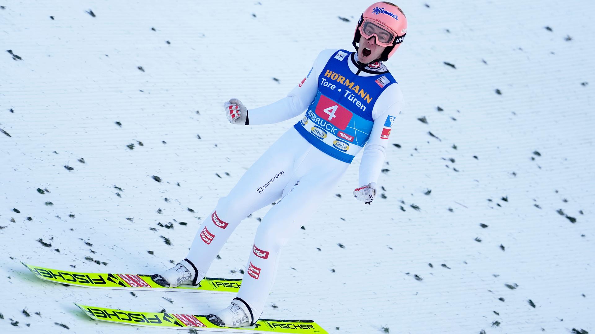 Kraft steht jubelnd auf den Ski und ballt beide Fäuste.