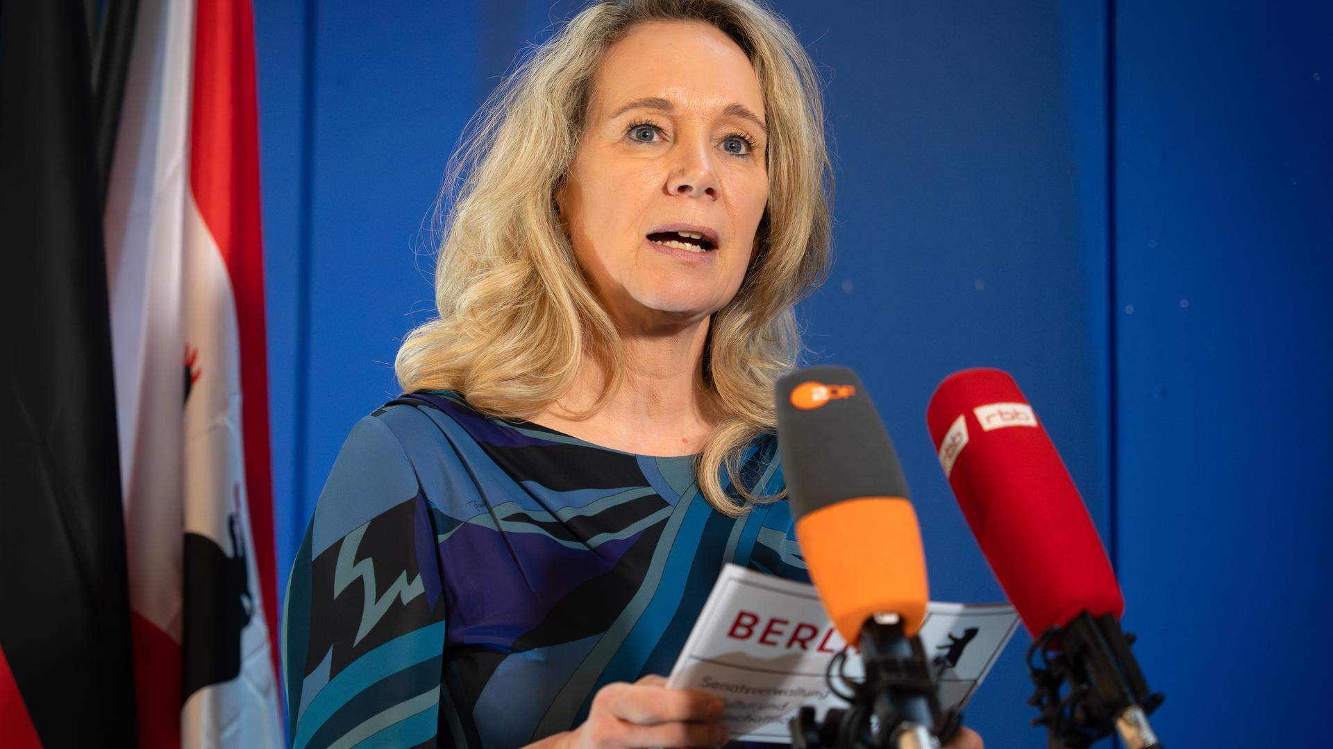 Berlins Kultursenatorin Wedl-Wilson steht vor Mikrofonen und liest eine Erklärung ab.