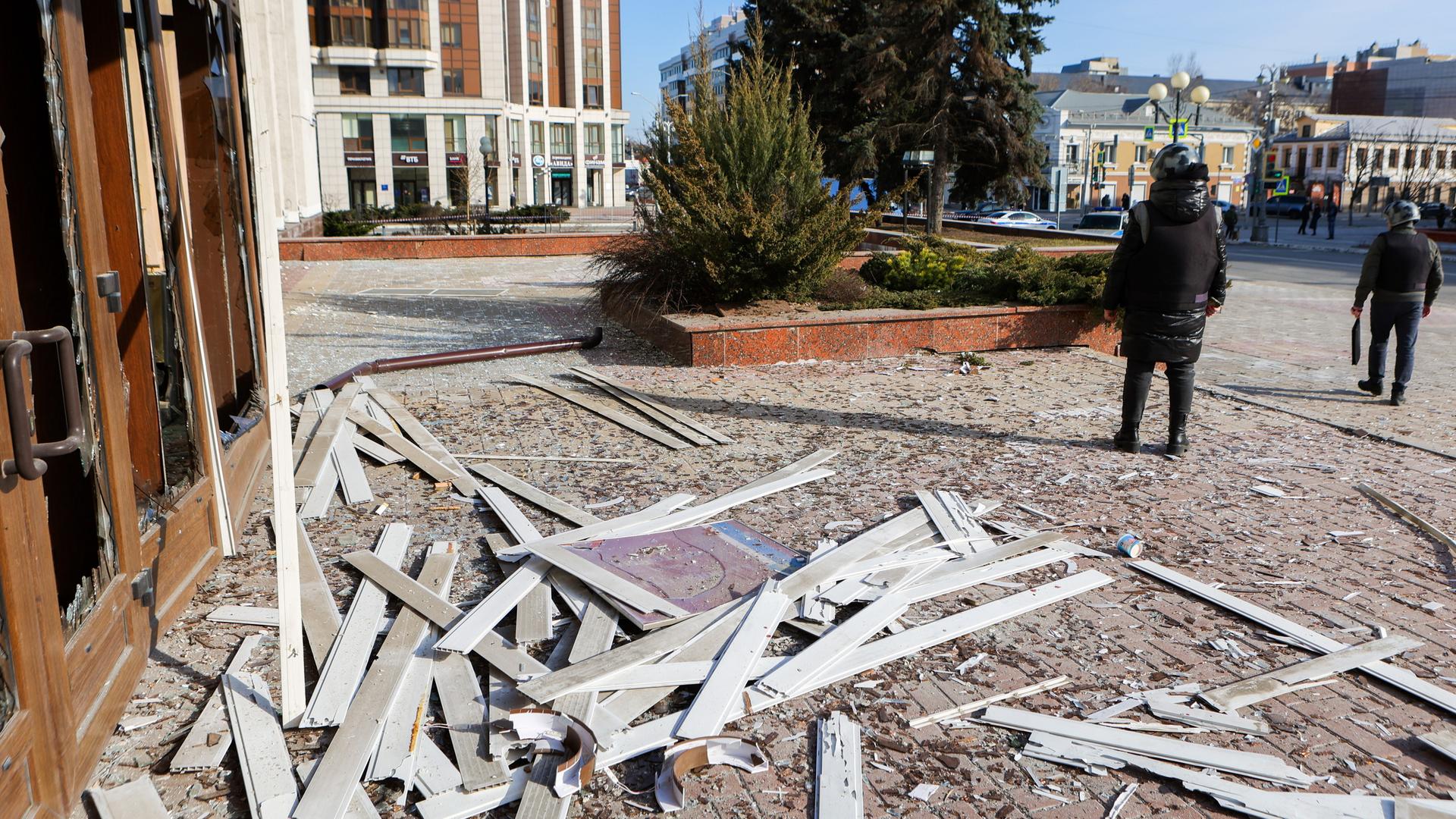 Ein nach einem ukrainischen Drohnenangriff zerstörtes Haus in Belgorod, Russland. Rechts im Bild gehen zwei Soldaten.