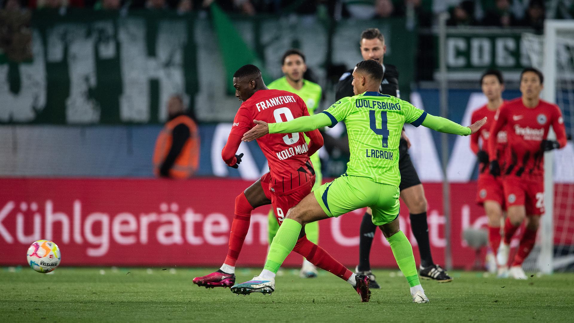 Frankfurts Randal Kolo Muani (l) und Wolfsburgs Maxence Lacroix kämpfen um den Ball. Frankfurts Randal Kolo Muani (l) und Wolfsburgs Maxence Lacroix kämpfen um den Ball.