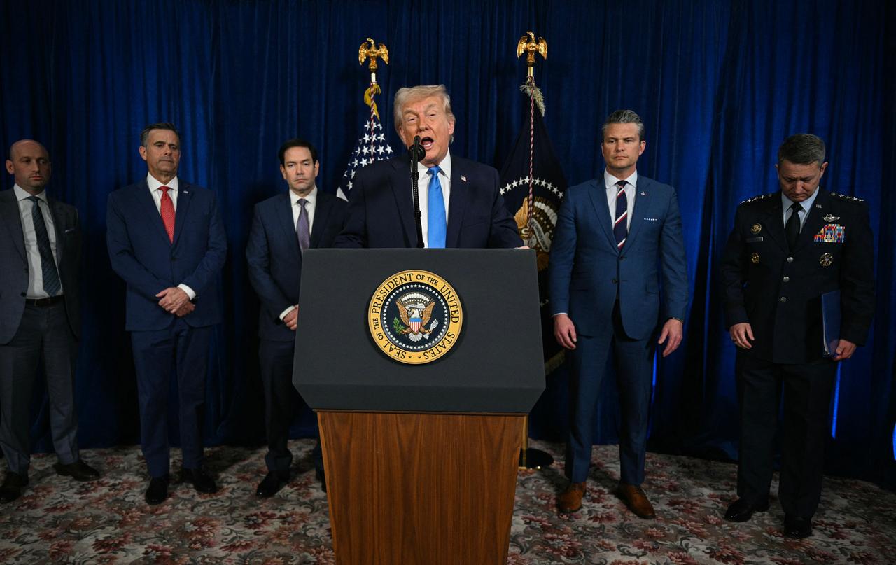 Trump spricht hinter einem Rednerpult. Hinter ihm stehen Mitglieder der US-Regierung. Trump spricht hinter einem Rednerpult. Hinter ihm stehen Mitglieder der US-Regierung.