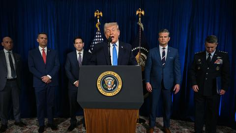 Trump spricht hinter einem Rednerpult. Hinter ihm stehen Mitglieder der US-Regierung.