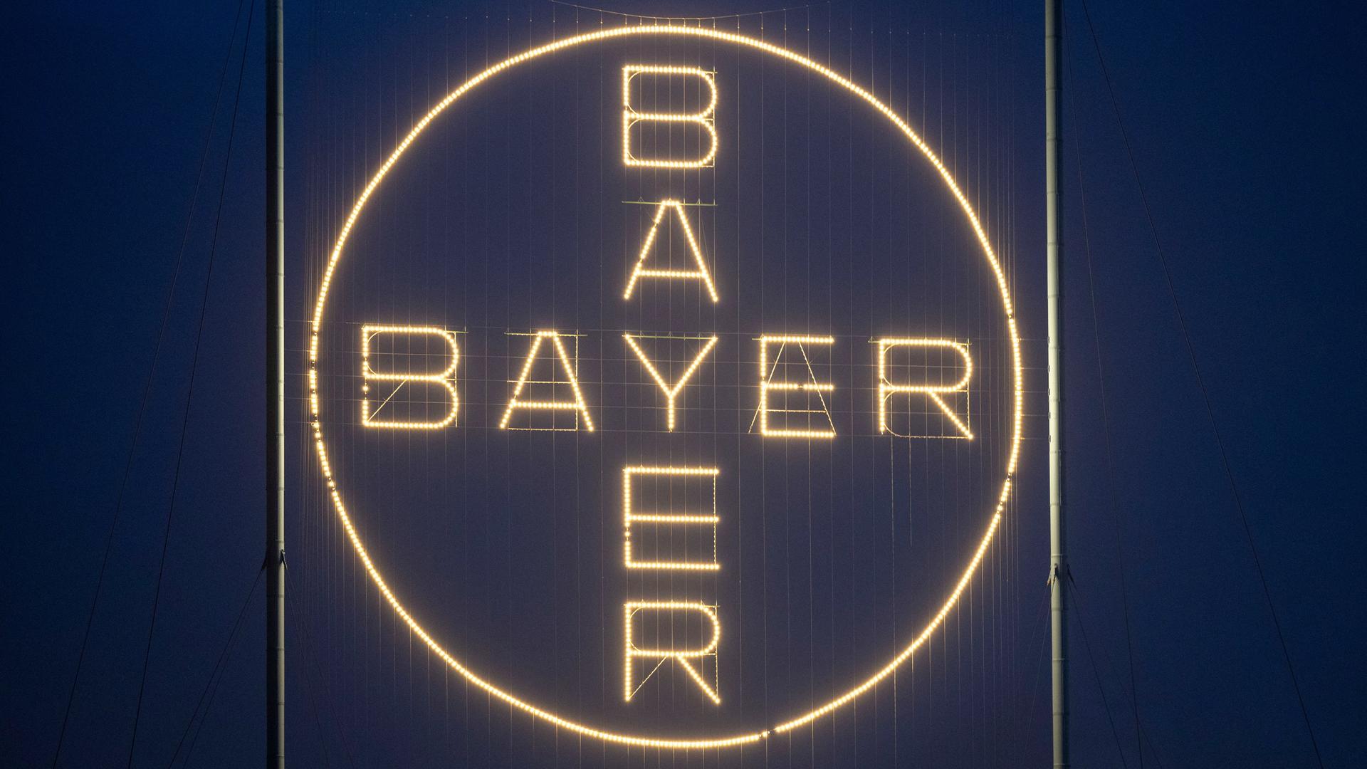 Das Bayer Kreuz, das Logo des Unternehmens, leuchtet auf dem Werksgelände in Leverkusen. 