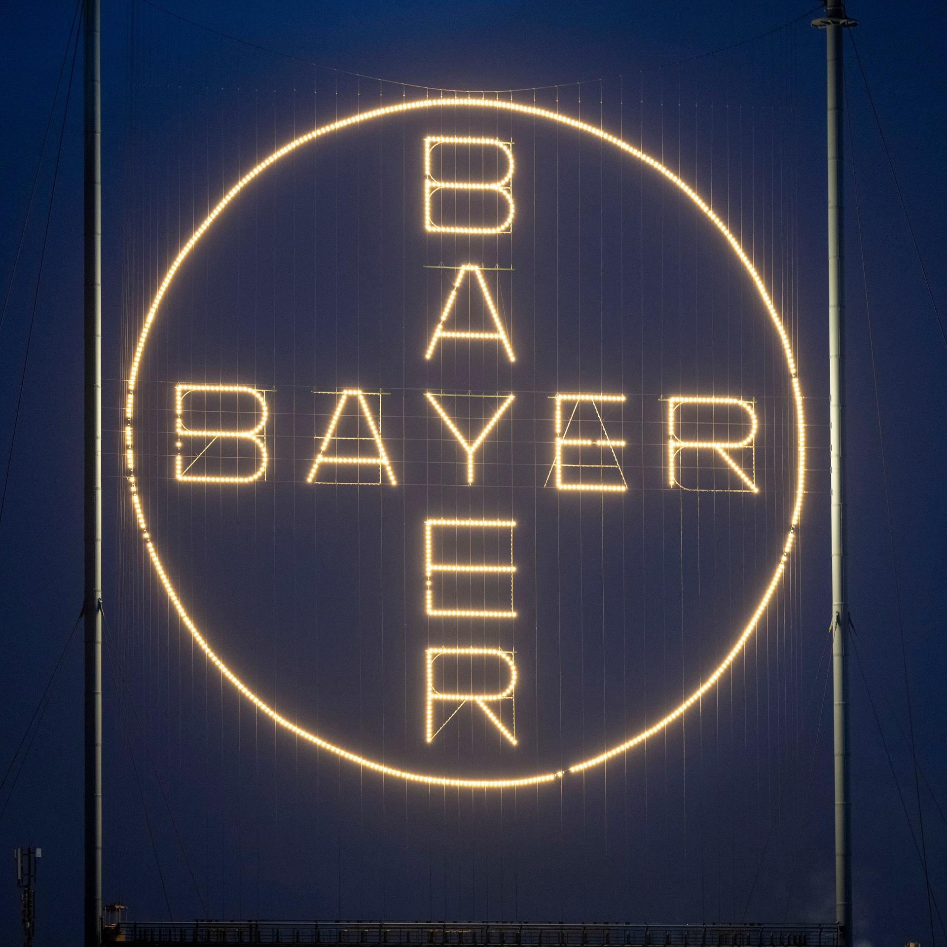 Das Bayer Kreuz, das Logo des Unternehmens, leuchtet auf dem Werksgelände in Leverkusen. 