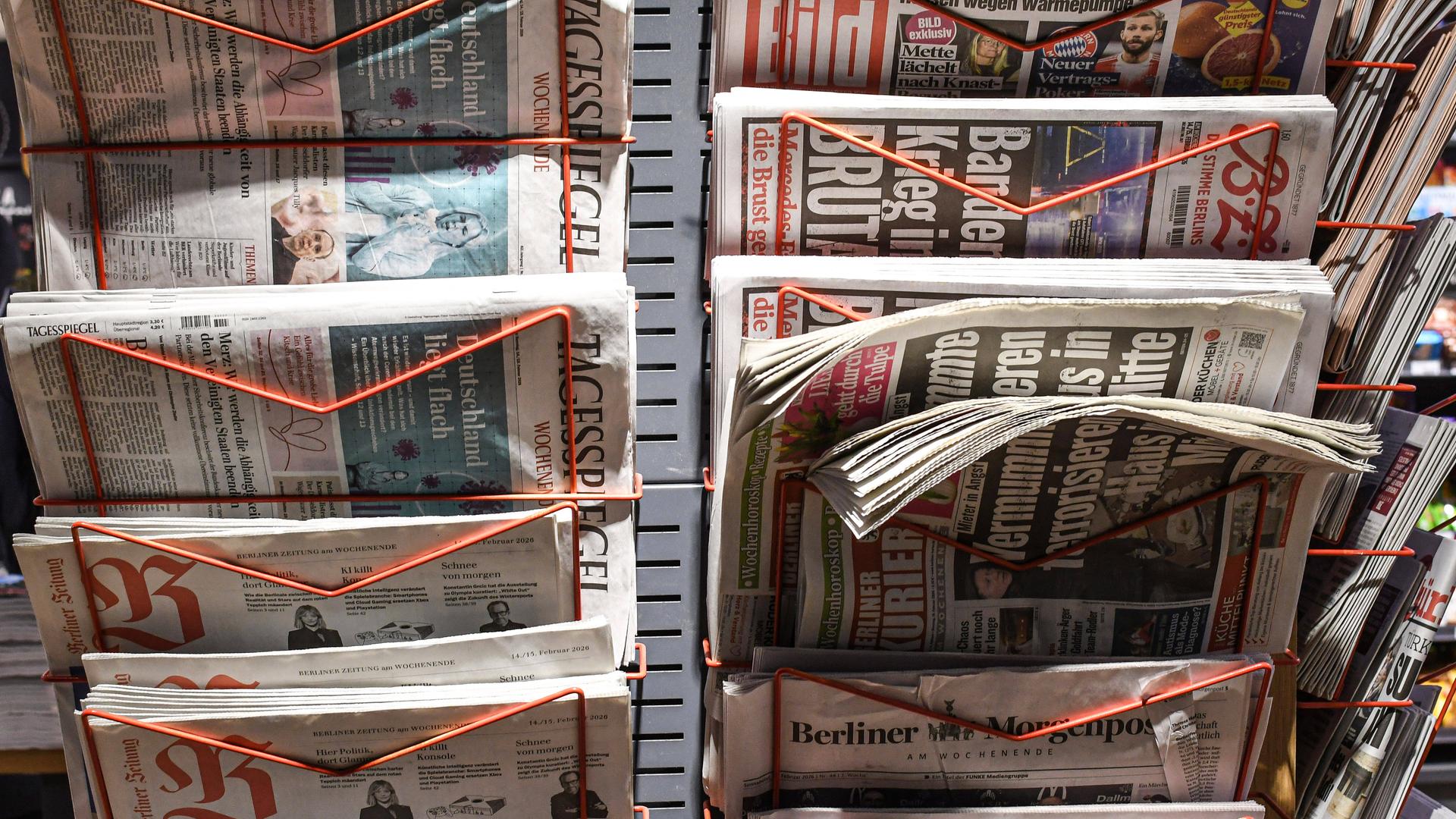 Zeitungen stecken in einem Zeitungsstaender in einem Laden im Berliner Hauptbahnhof Zeitungen stecken in einem Zeitungsstaender in einem Laden im Berliner Hauptbahnhof