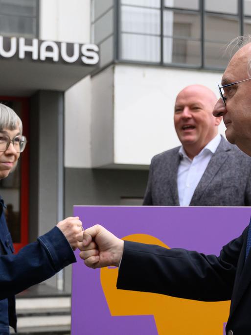 Barbara Steiner, Direktorin der Stiftung Bauhaus Dessau, und Reiner Haseloff (CDU, r), Ministerpräsident von Sachsen-Anhalt, stehen vor dem Bauhausgebäude in Dessau. Vor 100 Jahren zog das Bauhaus von Weimar nach Dessau. 