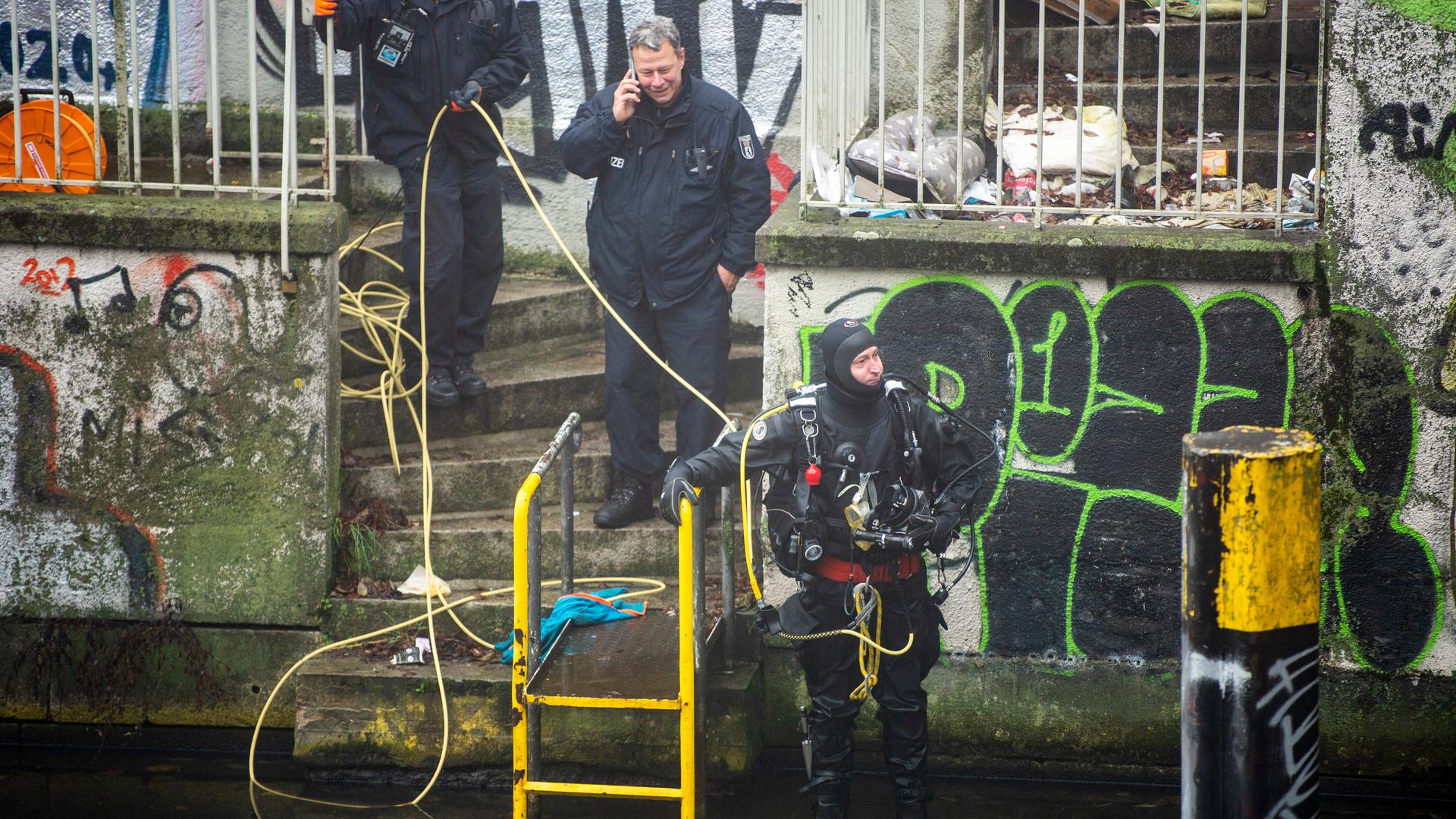 Ein Polizeitaucher steht am Ufer des Landwehrkanals in Berlin-Neukölln. Ein Polizeitaucher steht am Ufer des Landwehrkanals in Berlin-Neukölln.
