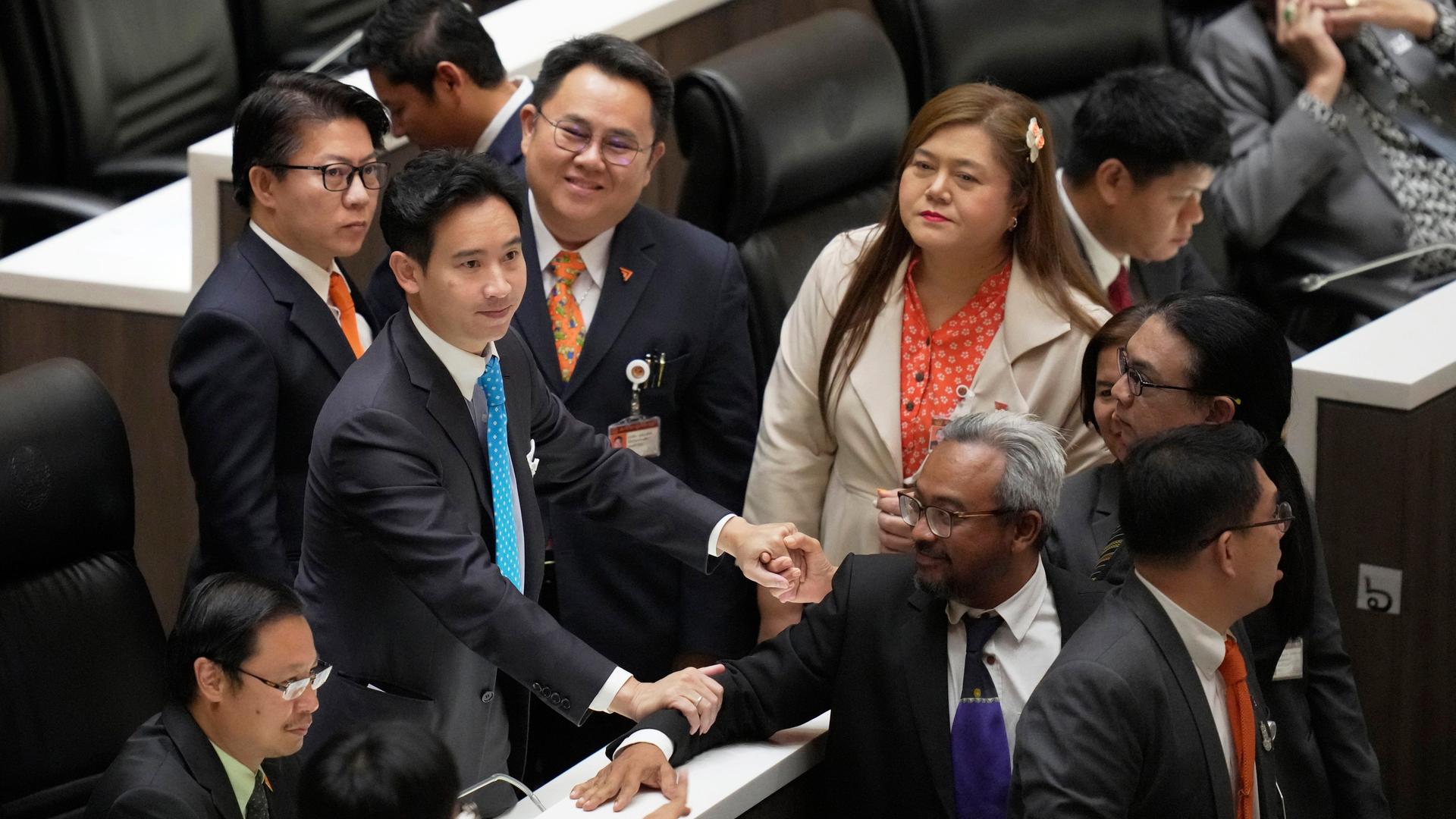 Thailand, Bangkok: Pita Limjaroenrat (l), Vorsitzender der Move Forward Party und Spitzenkandidat nimmt Glückwünsche von Abgeordneten der Partei während einer Sitzung im Parlament entgegen.