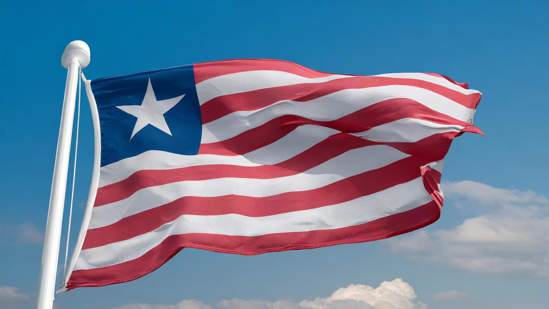 Die Fahne von Liberia, flattert im Wind, isoliert, gegen den blauen Himmel.