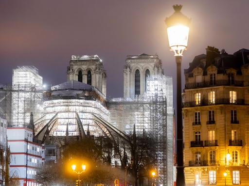 Eine Ansicht der nächtlich beleuchteten Kathedrale Notre Dame in Paris mit Baugerüsten