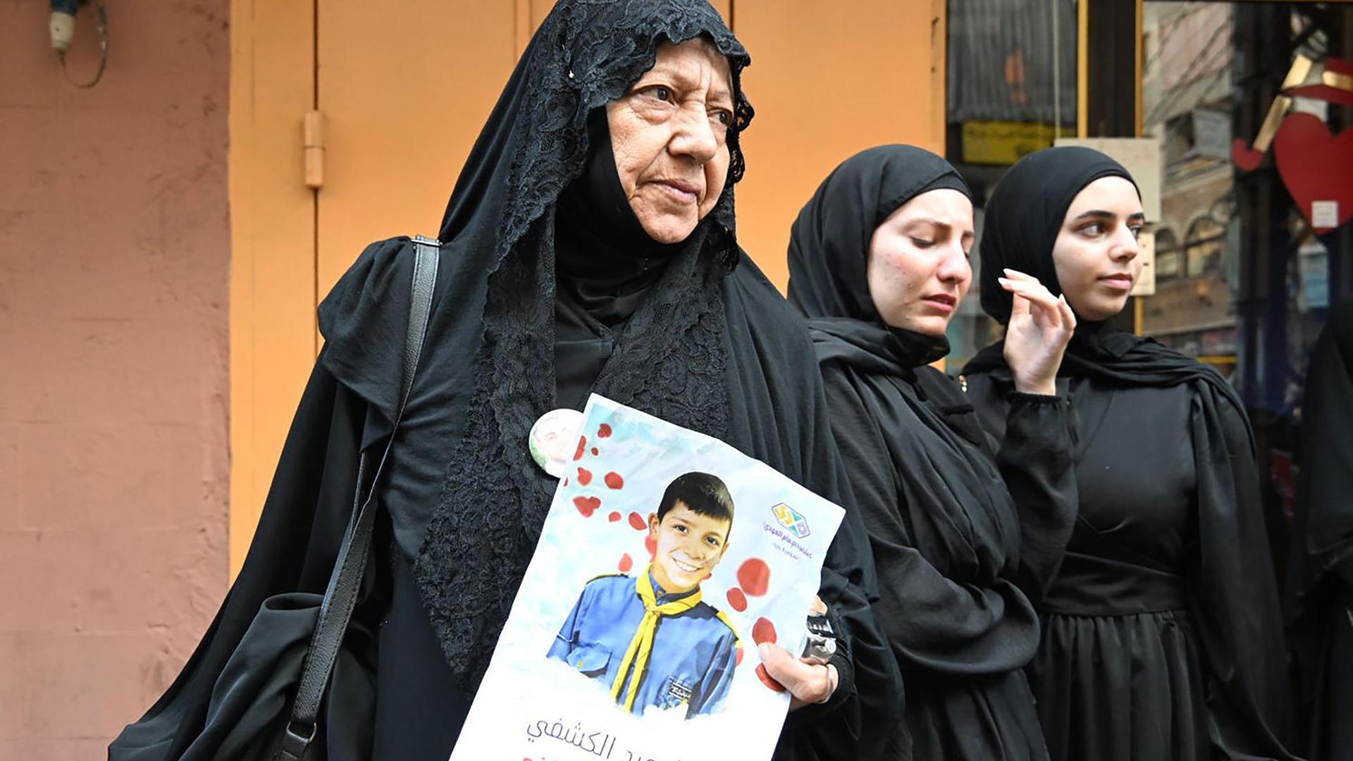 Angehörige trauern bei der Trauerfeier für Menschen, die im Libanon getötet wurden, als von Hisbollah-Mitgliedern benutzte Pager zur Explosion gebracht wurden. Eine Frau hält das Bild eines Kindes in der Hand. Libanon, 18. September 2024.