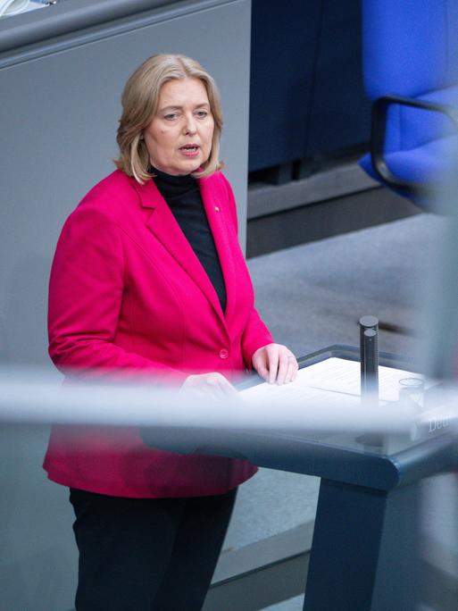 Die Bundesministerin für Arbeit und Soziales Bärbel Bas bei einer Rede im Bundestag in Berlin. Auf dem Foto spiegelt sie sich zweimal.