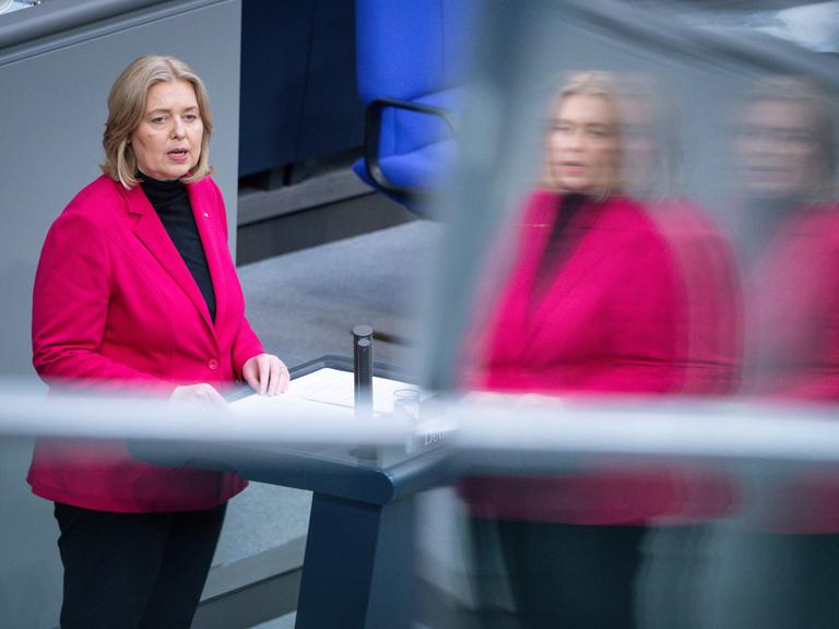 Die Bundesministerin für Arbeit und Soziales Bärbel Bas bei einer Rede im Bundestag in Berlin. Auf dem Foto spiegelt sie sich zweimal.