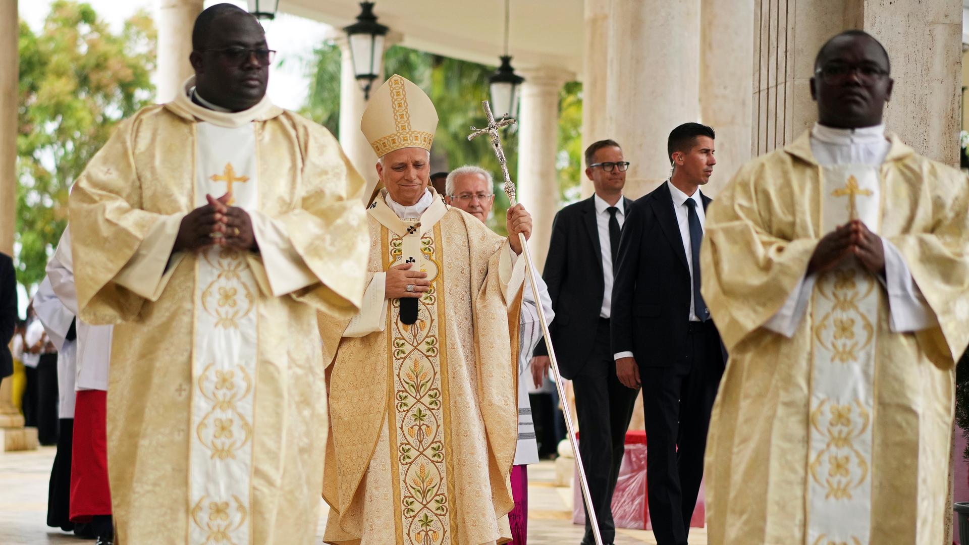 Äquatorialguinea, Mongomo: Papst Leo XIV. (M) kommt am zehnten Tag seines elftägigen Pastoralbesuchs in Afrika zur Heiligen Messe in der Basilika der Unbefleckten Empfängnis. Neben ihm gehen mehrere Personen.