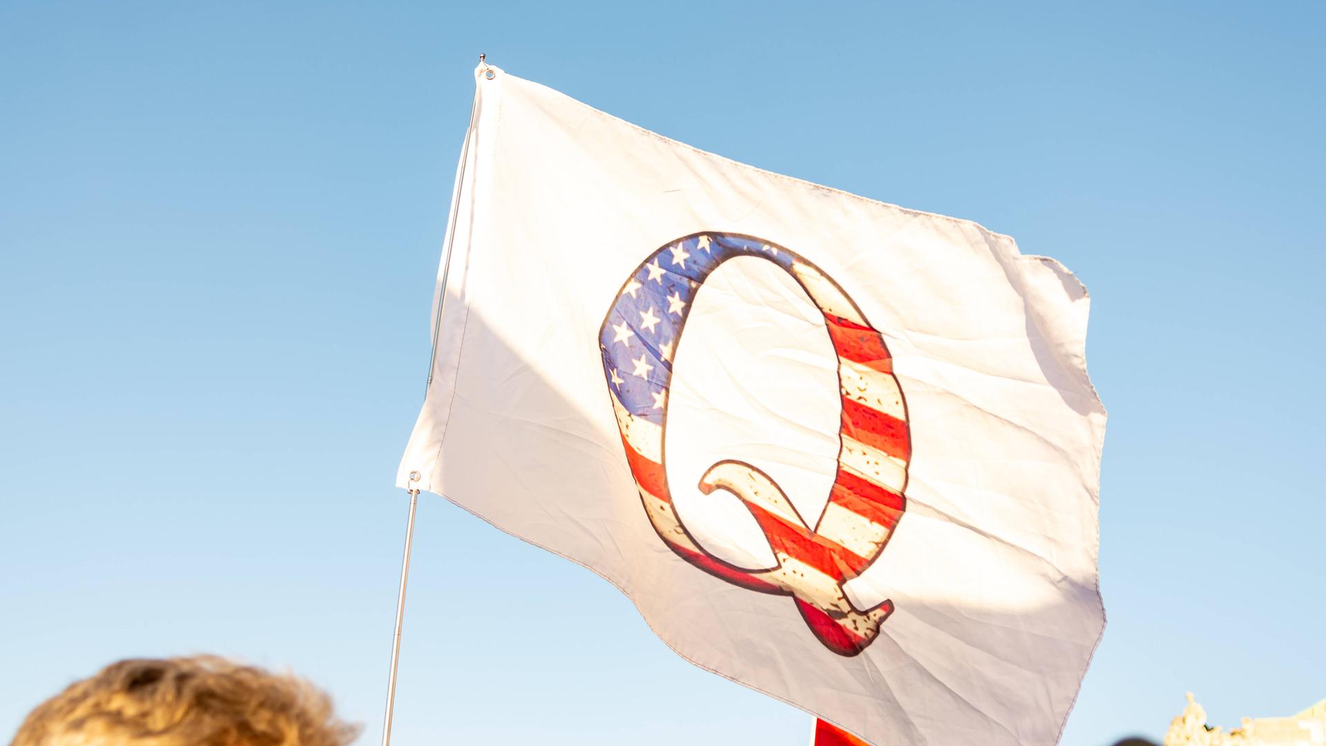 Eine Flagge mit dem Buchstaben Q des QAnon-Netzwerks. Eine Flagge mit dem Buchstaben Q des QAnon-Netzwerks.