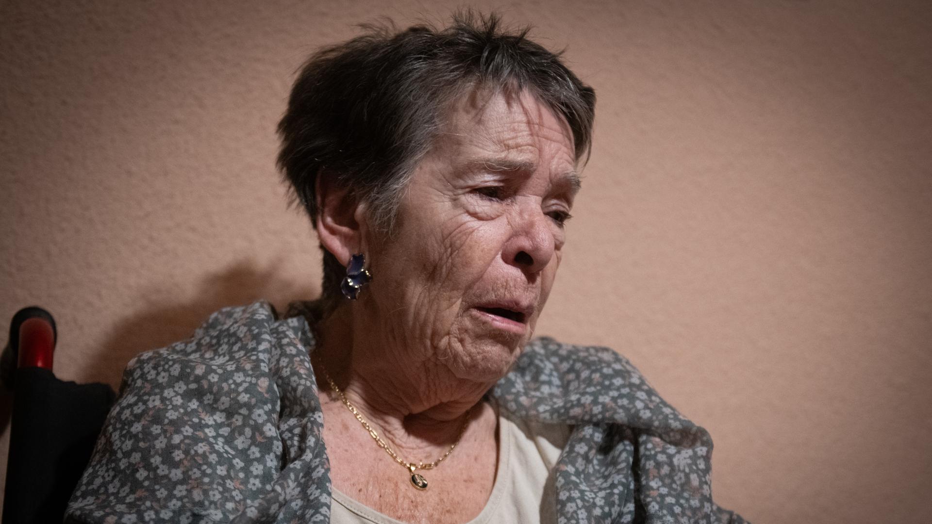 Die 87-Jährige Maricarmen sieht berschöpft aus. Das BIld zeigt ihren Oberkörper vor einer beigen Wand. 