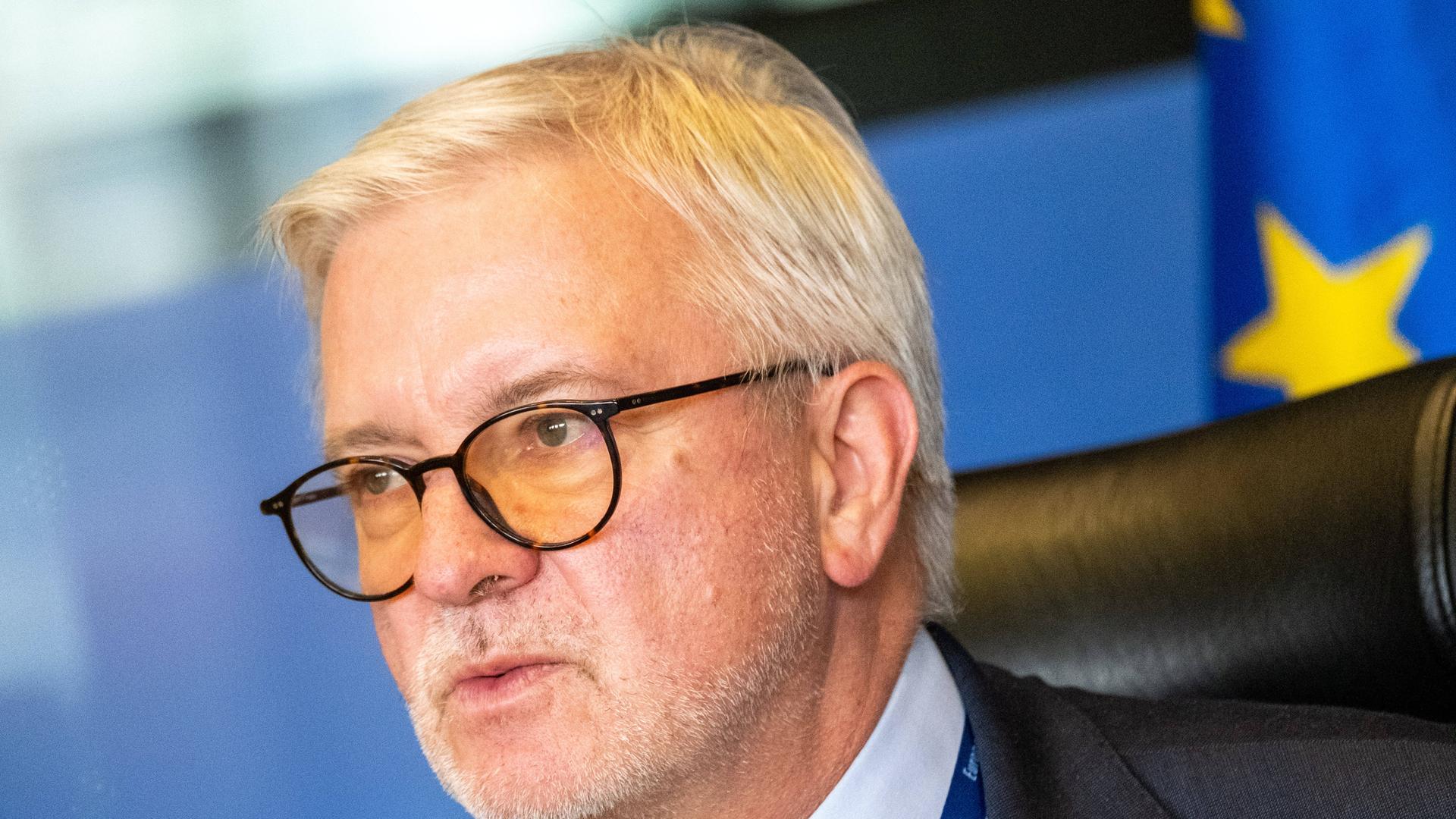 Porträit Michael Gahler. Im Hintergrund sind Teile der Europaflagge zu sehen. 
