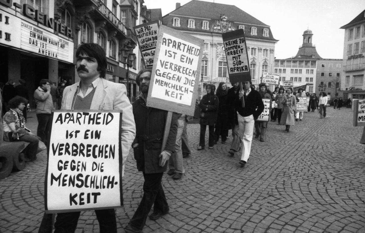 Schwarz-Weiß-Fotografie zeigt Studierende bei einer Protestdemo gegen die Apartheid in Südafrika am 06.04.1979 in Bonn.