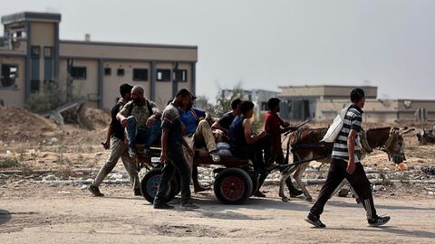 Eine Gruppe von Palästinenern auf und neben einem Eselskarren