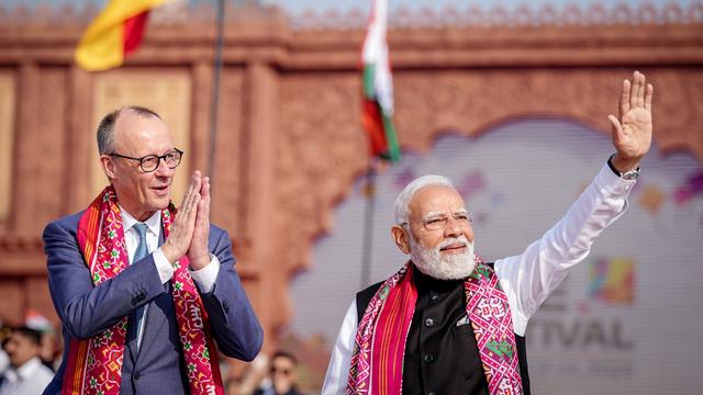 Friedrich Merz steht neben dem Premier-Minister von Indien. Es ist ein Mann mit weißen Haaren. Beide Männer tragen bunte Schals.