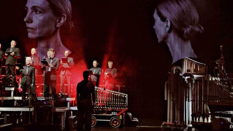 Der RIAS Kammerchor singt auf der Bühne, daneben mechanische Musikautomaten