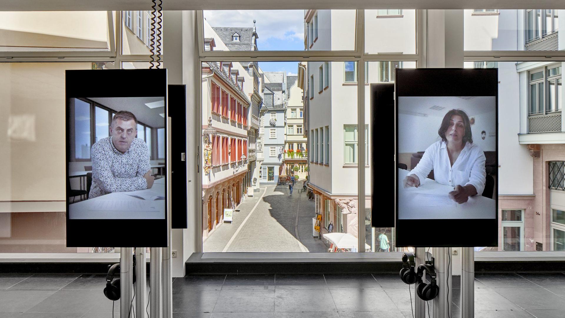 In der Frankfurter Ausstellung äußern sich Angehörige und Überlebende auf zwei Bildschirmen in Videos zum Attentat in Hanau.