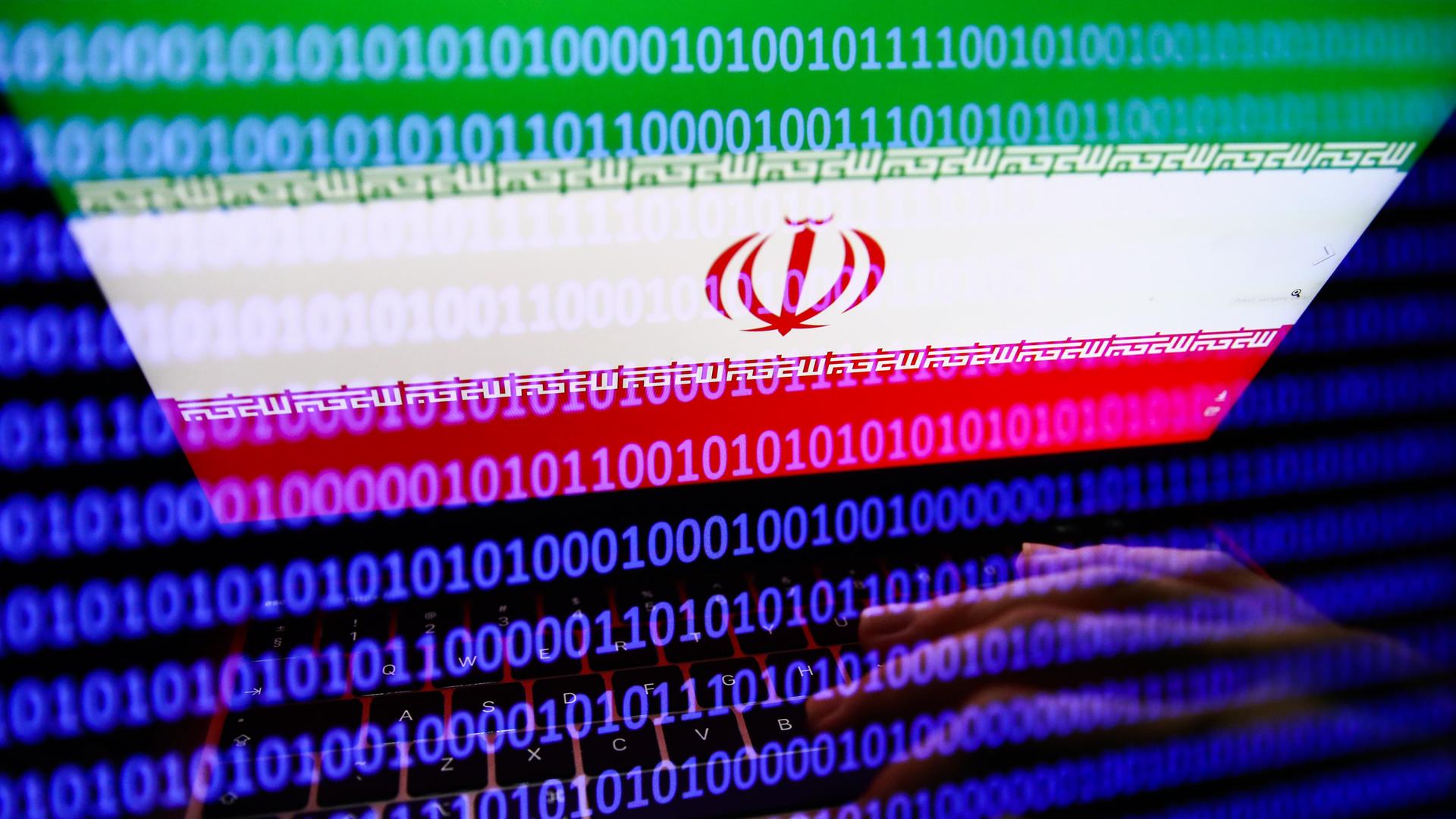 Die Flagge des Iran auf einem Laptop-Bildschirm. Darüber liegt ein binärer Code - Nullen und Einsen füllen den Bildschirm. 