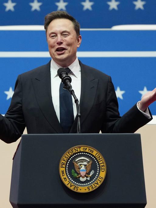 Tech-Milliardär Elon Musk spricht bei der Inaugurationsparade an einem Rednerpult mit dem Emblem des US-Präsidenten am 25. Januar 2025 in Washington.