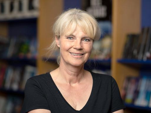 Porträt von Nele Neuhaus, im Hintergrund Bücherregale