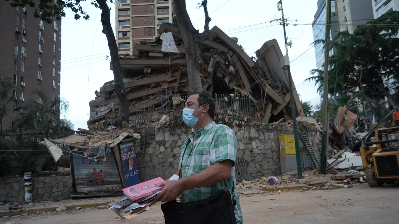 Ein Mann trägt Habseligkeiten aus einem eingestürzten Gebäude in Venezuelas Hauptstadt Caracas.