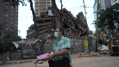 Ein Mann trägt Habseligkeiten, die er aus einem eingestürzten Gebäude geborgen hat, nach einem Erdbeben in Caracas, Venezuela.