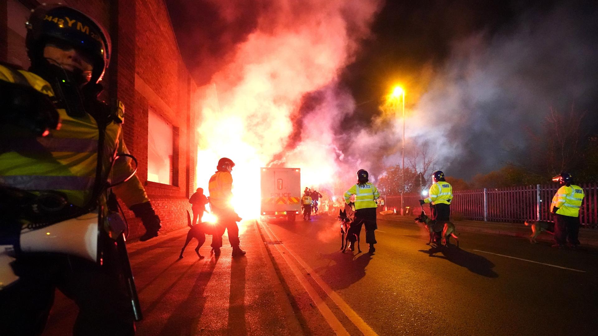 Birmingham: Fußball: Polizisten sind mit ihren Hunden im Einsatz, während vor dem Spiel im Villa Park Bengalfackeln vor dem Stadion gezündet werden.