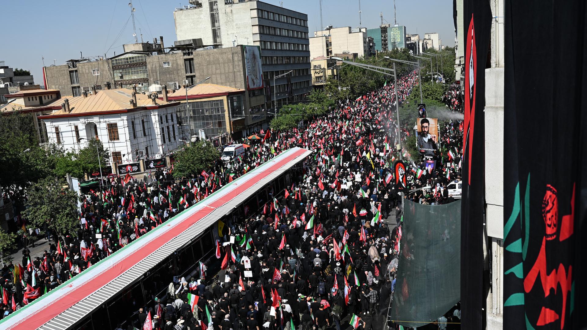Tausende Menschen laufen bei einem Trauerzug durch eine Straße in Teheran Tausende Menschen laufen bei einem Trauerzug durch eine Straße in Teheran