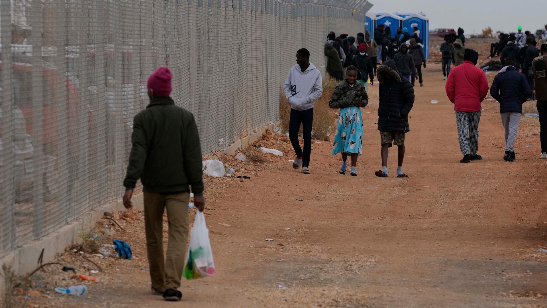 Personen in Zypern gehen an einem Zaun des Aufnahmezentrums für Migranten Pournara vorbei.